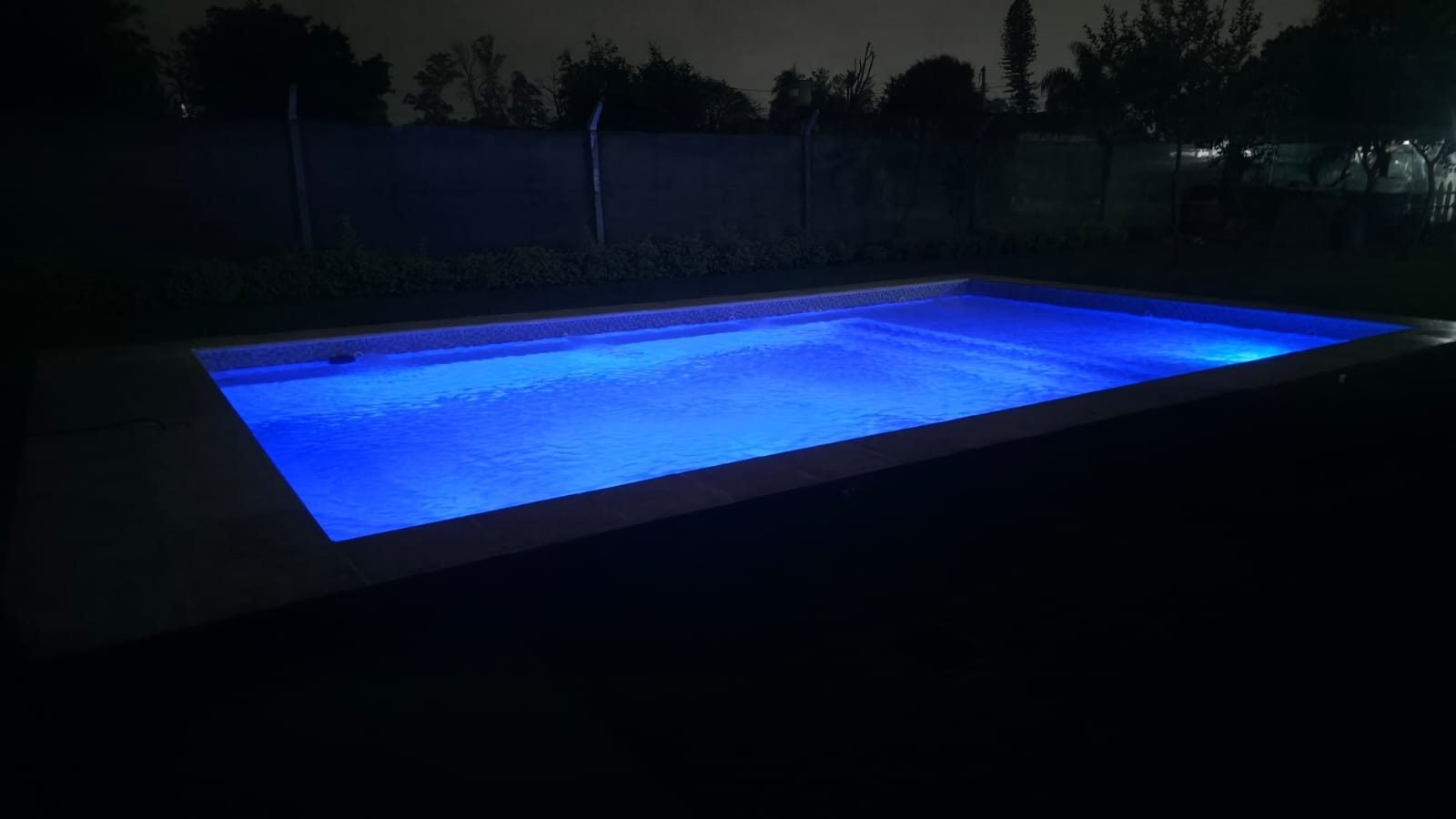 Pileta iluminada de color azul por la noche